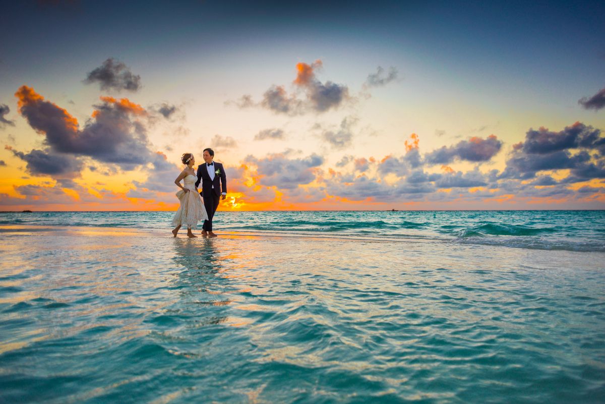 A couple holding each other during a warm outdoor wedding moment
